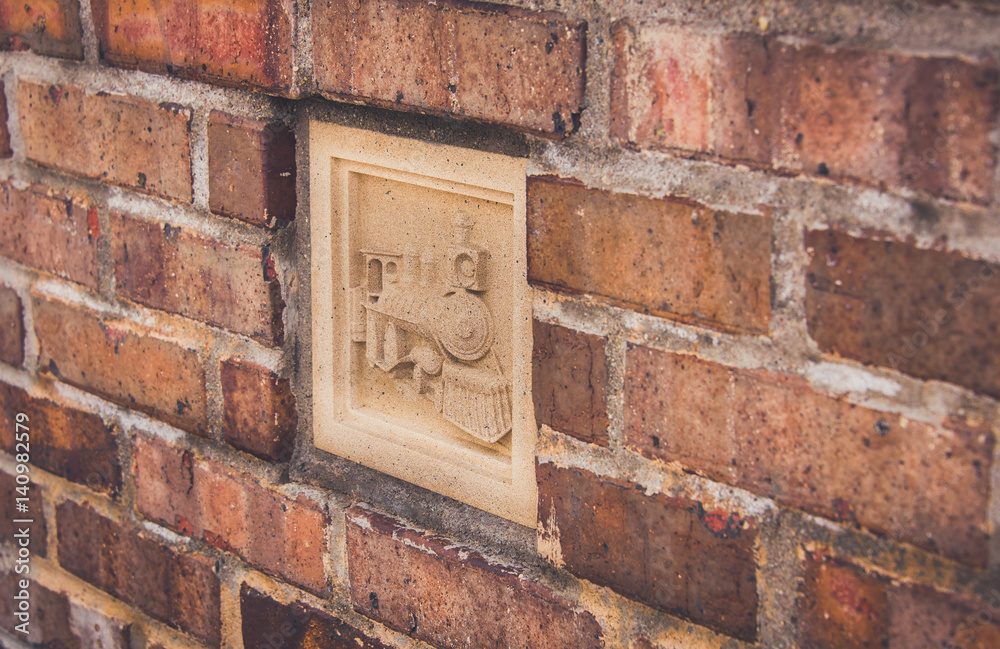 Old red brick wall texture grunge background with a locomotive inset