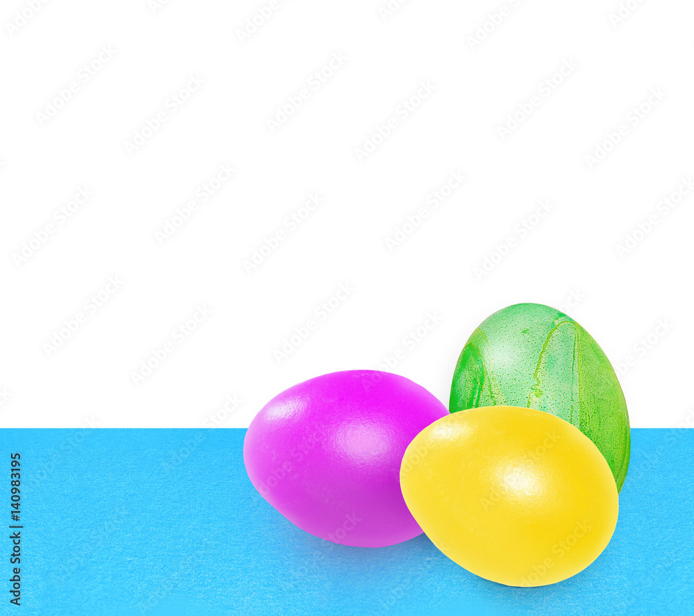 Three bright colorful easter eggs. Pink, yellow, green easter eggs on blue uneven background on white background Three bright colorful easter eggs. Pink, yellow, green easter eggs on blue uneven background on white background