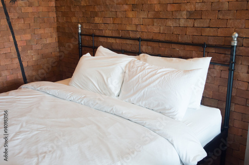 Empty bed with brown brick wall