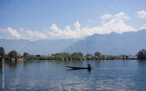 Person in canoe travelling across river in India