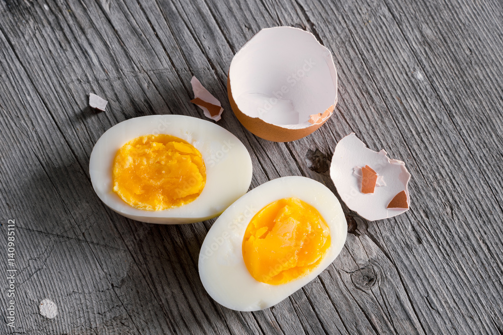 Sliced hard boiled eggs on wooden cutting board Sliced hard boiled eggs on wooden cutting board