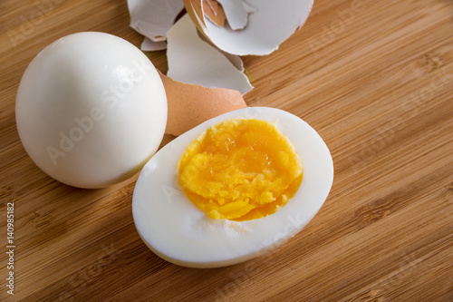 Sliced hard boiled eggs on wooden cutting board
