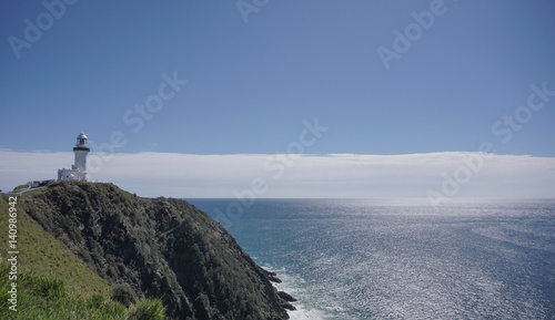 Lighthouse on edge of cliff overlooking ocean on clear day