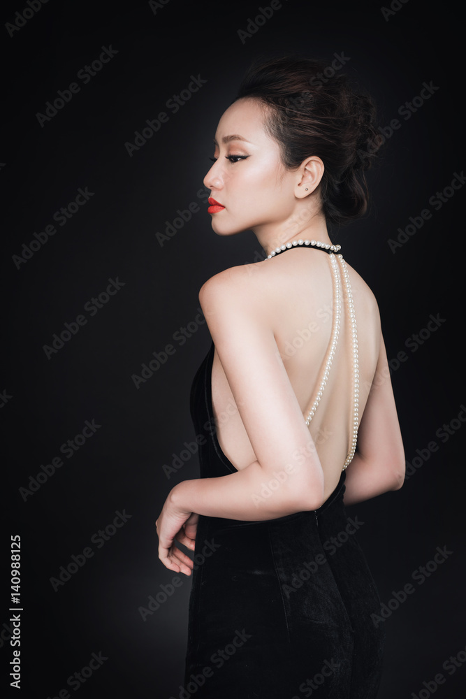 Fototapeta premium Asian woman with fashion makeup in luxury black dress while confetti falling on her.