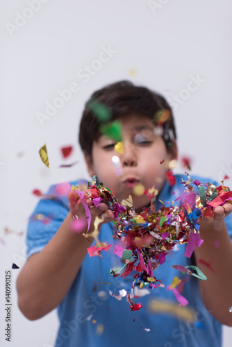 kid blowing confetti