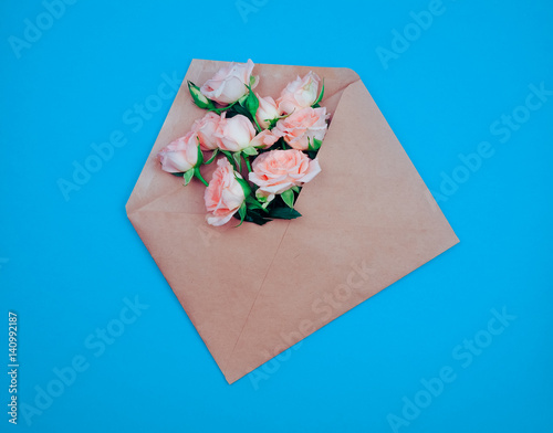 the Kraft envelope on a wood background with roses, concept, holiday, gift, copy space for text © byallasaa