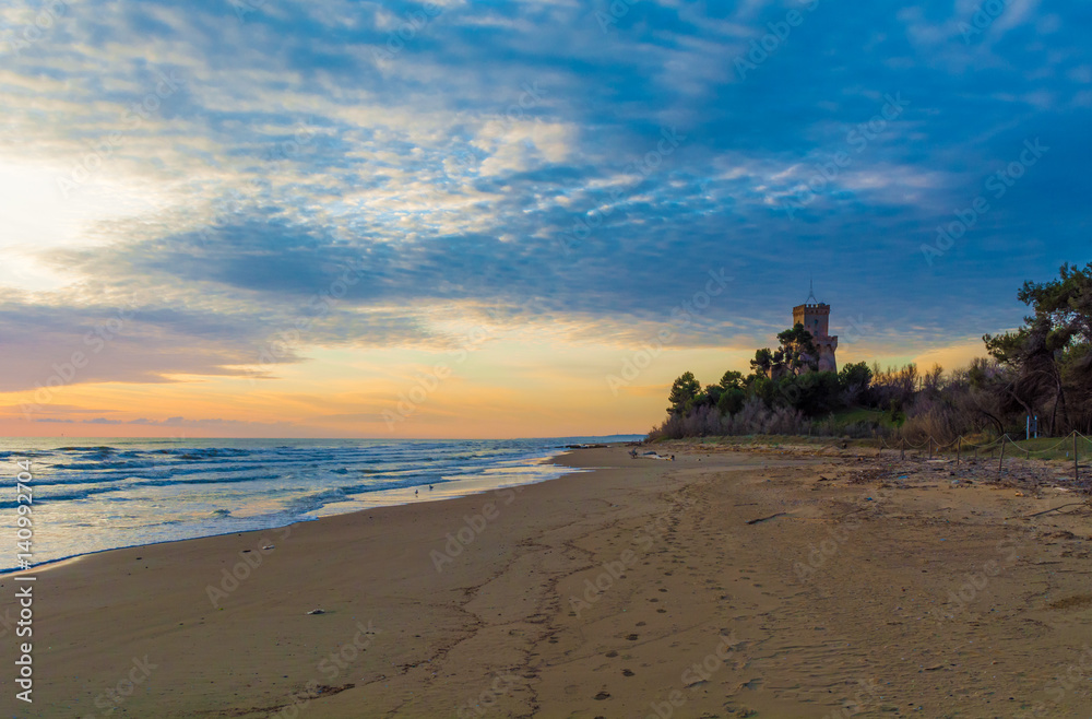 Fototapeta premium Pineto (Abruzzo, Italy) - The sunrise on the Adriatic sea, from the Pineto beach, beside the Torre di Cerrano castle
