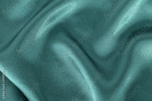Silk background, texture of green shiny fabric,