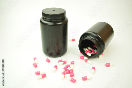 A black plastic bottle with pills