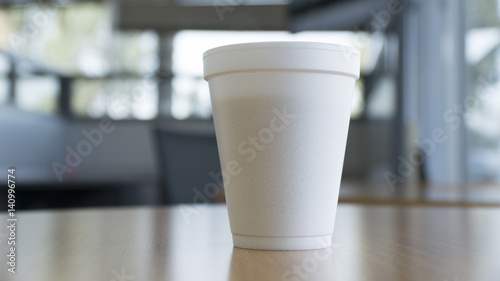 disposable coffee cup on table in a large bright room