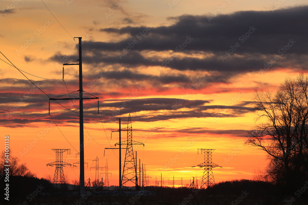 transmission line on a background of bright red sunset