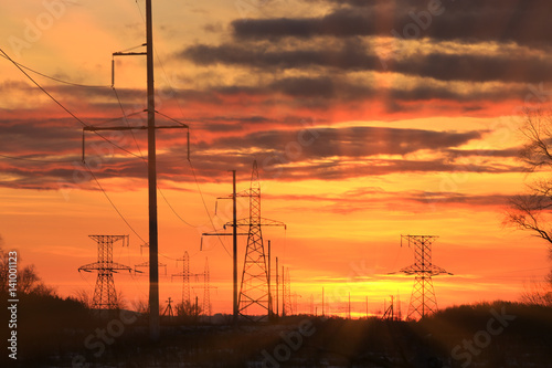 transmission line on a background of bright red sunset