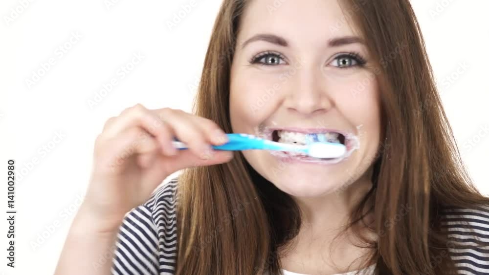 Woman dark long hair brushing cleaning teeth. Positive girl with toothbrush. Oral hygiene. Studio shot isolated on white background 4K ProRes HQ codec Woman dark long hair brushing cleaning teeth. Positive girl with toothbrush. Oral hygiene. Studio shot isolated on white background 4K ProRes HQ codec