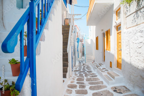 Empty narrow streets of greek island with trees. Beautiful architecture building exterior with cycladic style. © travnikovstudio