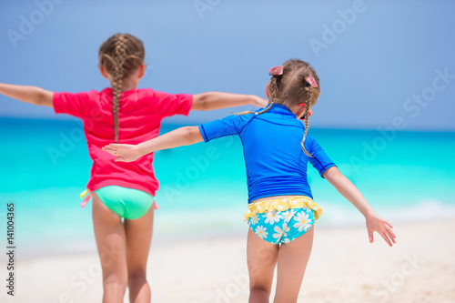 Little girls have fun at tropical beach playing together