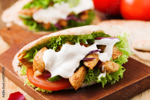 Pita salad with roasted chicken and vegetables, served with a delicious sauce.