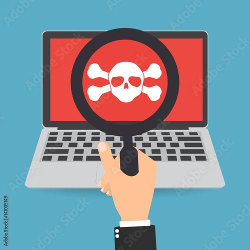 Businessman hand with magnifying glass with skull crossbones logo on laptop screen on red background.Concept of network security or computer virus.