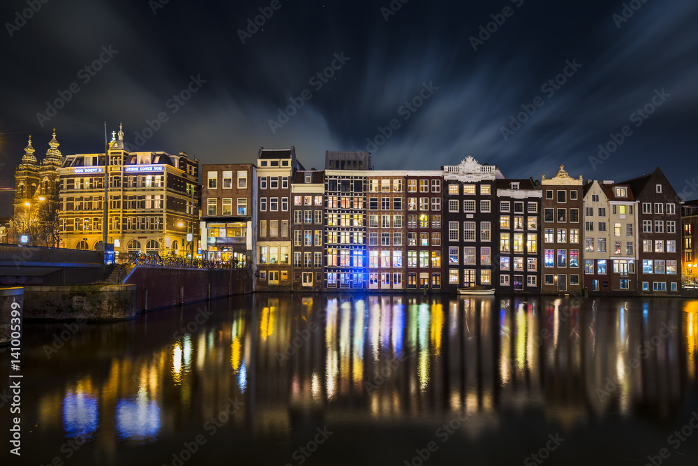 Traditional Dutch old houses on the canals in Amsterdam at night, The Netherlands