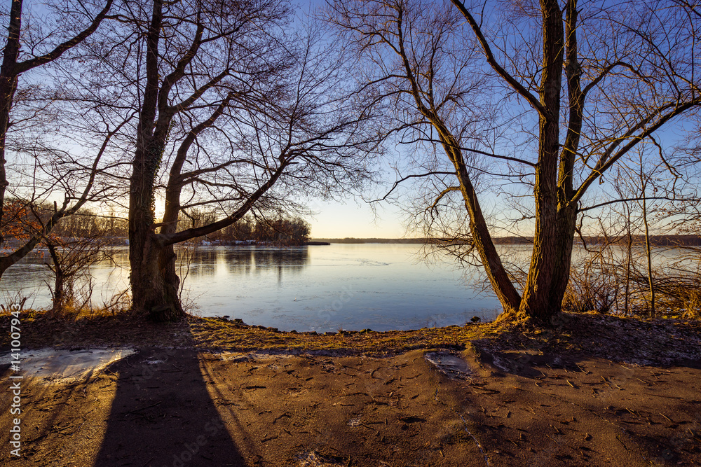 sunset over a snow covered lake in winter sunset over a snow covered lake in winter