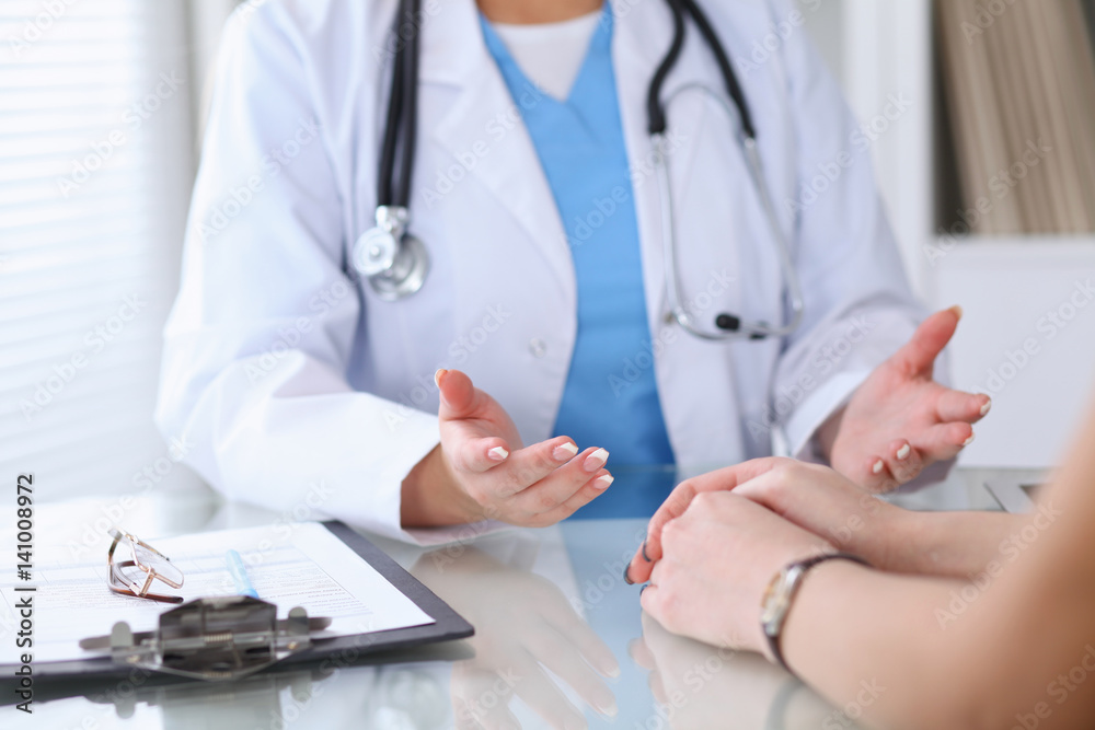 Close up of a doctor and patient hands discussing something while sitting at the table . Medicine and health care concept Close up of a doctor and patient hands discussing something while sitting at the table . Medicine and health care concept