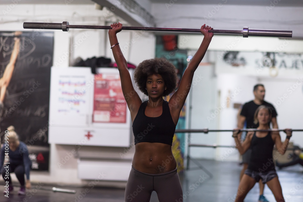 Fototapeta premium black woman lifting empty bar