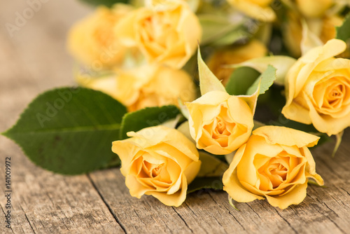 Yellow roses on vintage  rustic wooden background