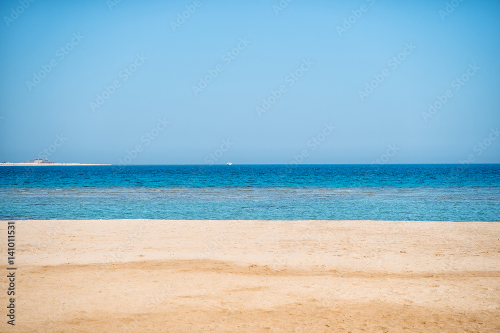 beautiful beach with sand, blue sky, water with boat