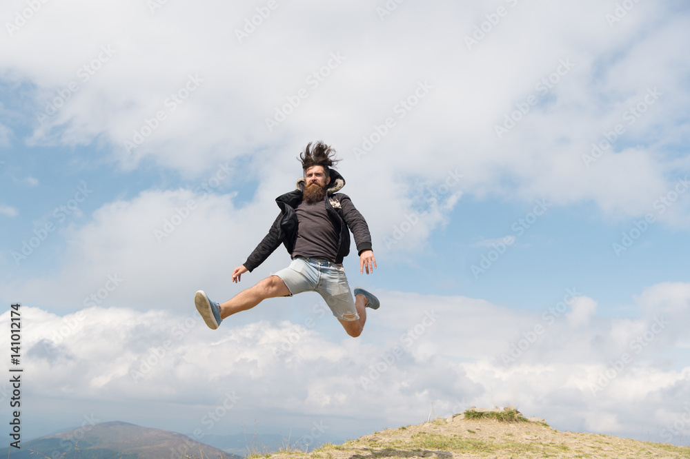 bearded man, brutal caucasian hipster with moustache jump on mountain
