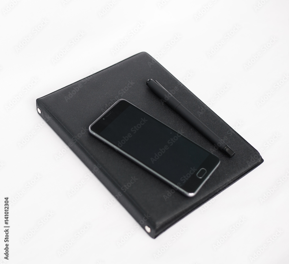White office desk table with laptop, smartphone, notebook and pen. White office desk table with laptop, smartphone, notebook and pen.