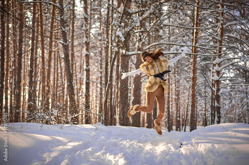 beautiful girl in fur vest in winter forest