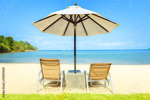 Fototapeta Naklejka Na Ścianę i Meble -  Beach chairs on the white sand beach with cloudy blue sky
