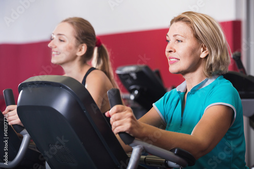 Elderly and young women working out in gym