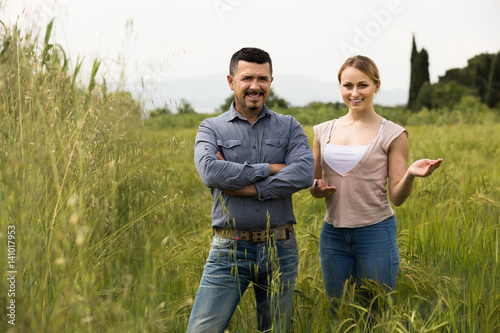 Man and woman standing in green wheat field