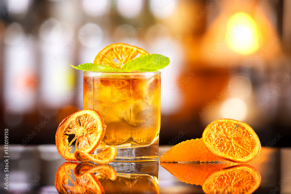 Φωτογραφία Closeup glass of mai tai cocktail decorated with orange chips and mint at bar counter background
