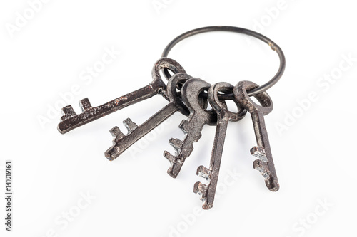 Five antique rural keys at metal ring isolated at white background. photo