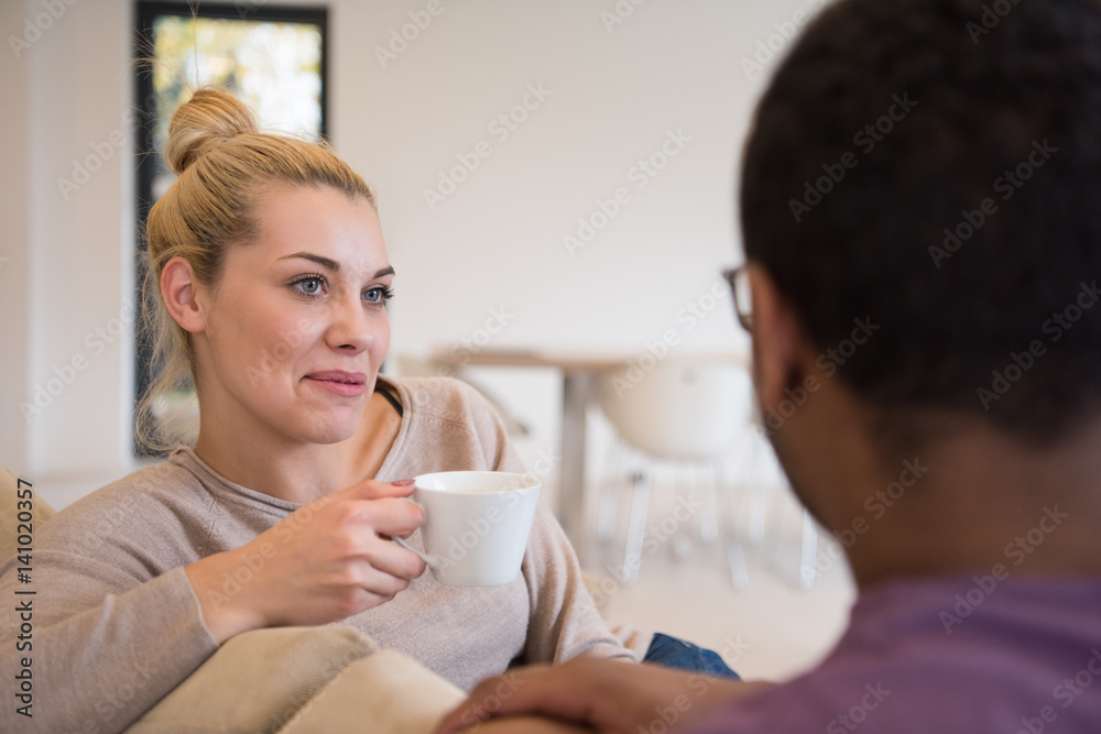 Young multiethnic couple in front of fireplace Young multiethnic couple in front of fireplace