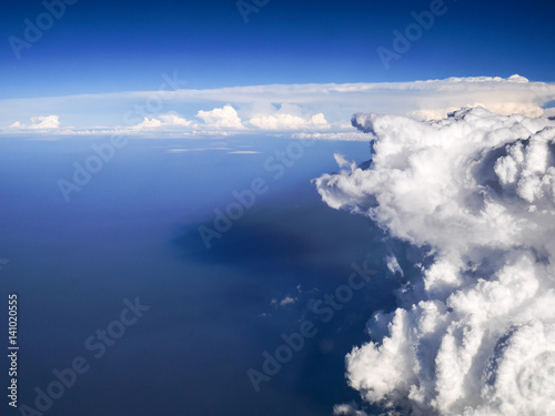 Spectacular aerial view from airplane window, beautiful, unique and picturesque white clouds with deep blue sky background, amazing and unique cloudy sky with sunlight and shadow  photo