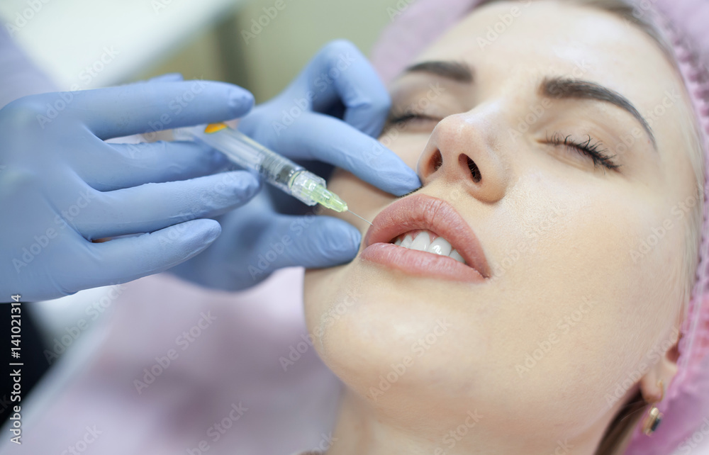 Woman gets injection in her face. Beauty woman giving injections. Young woman gets beauty facial injections in the cosmetology salon. Face aging injection. Aesthetic Medicine, Cosmetology Woman gets injection in her face. Beauty woman giving injections. Young woman gets beauty facial injections in the cosmetology salon. Face aging injection. Aesthetic Medicine, Cosmetology