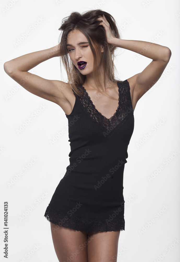 Beautiful young brunette woman in a black leather dress. Perfect body and figure. Elegant and sexy dress. Long legs. Fashion portrait. Beautiful young brunette woman in a black leather dress. Perfect body and figure. Elegant and sexy dress. Long legs. Fashion portrait.