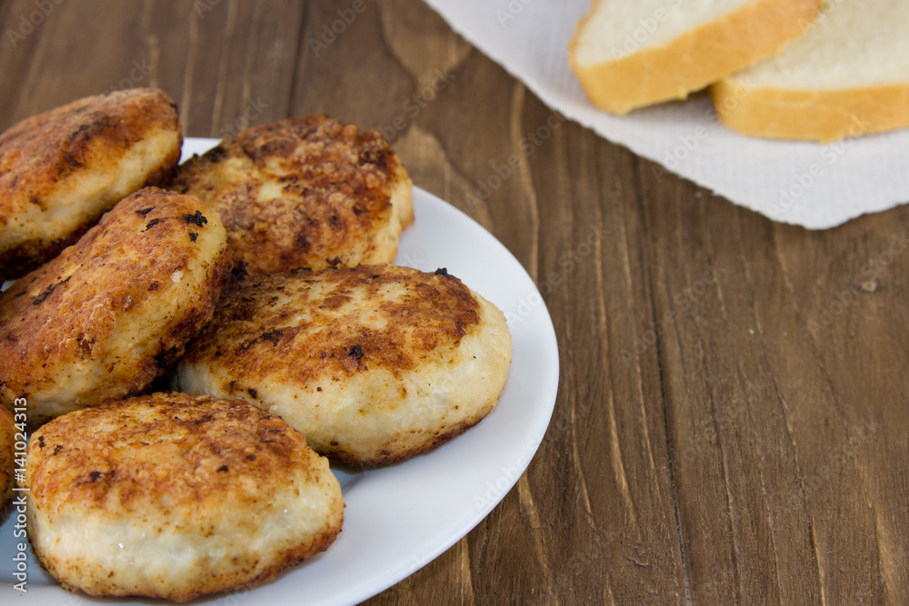 Fresh meat cutlet in plate isolated on a wooden background. Close up