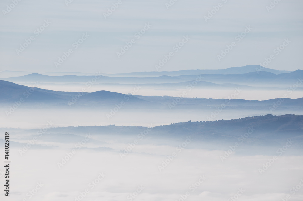 Distant hills and mountains above a sea of fog and mist