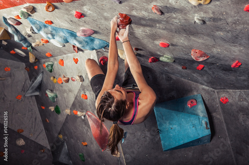 woman training on practice climbing wall indoor