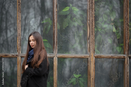 Portrait of a beautiful girl on the background of a large window