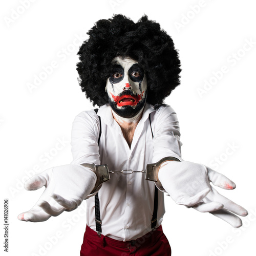 Killer clown with handcuffs © luismolinero