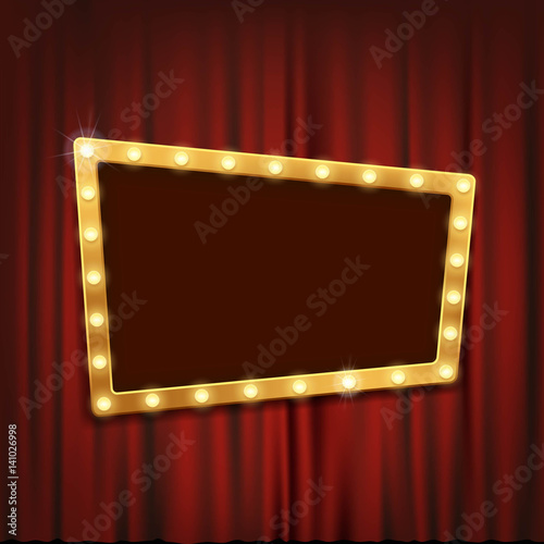 Gold frame with light bulbs on the red theatrical curtain.
