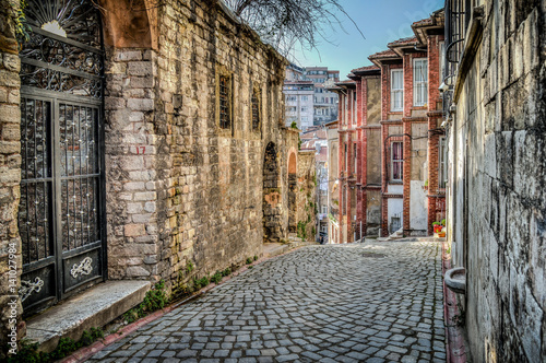 Istanbul, Turkey - March 2, 2013: Traditional stone street and houses at Fener District .Fener is a neighborhood midway up the Golden Horn within the district of Fatih in Istanbul. photo
