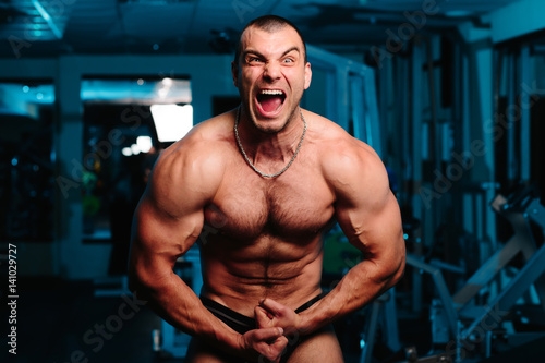 Screaming man with well trained body, biceps