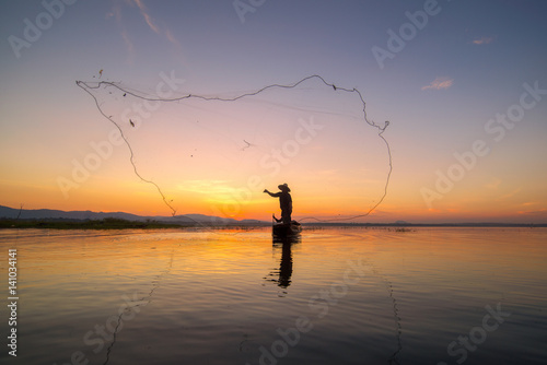 Fishermen fishing in the early morning golden ligh
