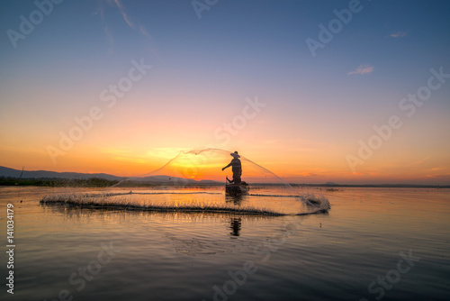 Fishermen fishing in the early morning golden ligh