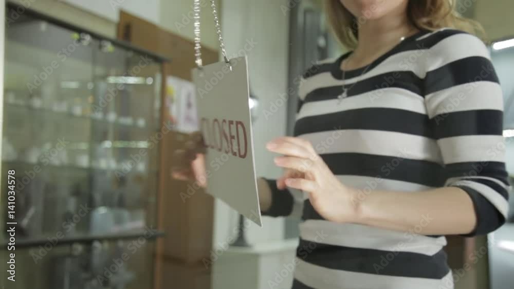 Woman opens store and flipping nameplate with closed sign Woman opens store and flipping nameplate with closed sign